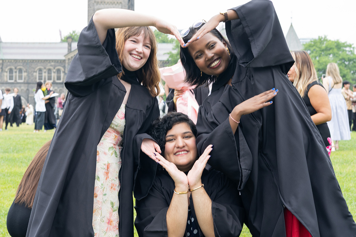 Graduates form a heart with their hands
