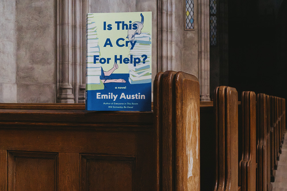 A book titled "Is this a Cry for Help" Propped up on the back of a church pew