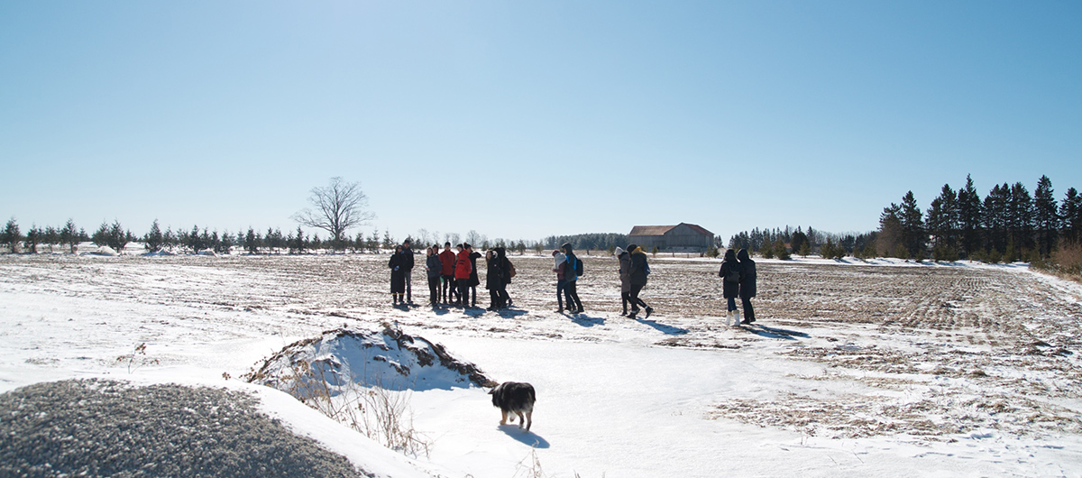 Trinity One Students walk across the frozen field at New Farm