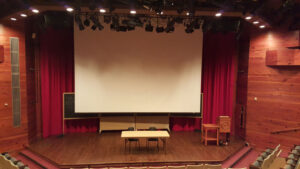 Classroom Setup on the GIT Stage with a trestle table in the centre, the podium stage left, and the projection screen in front of the blackboards. 