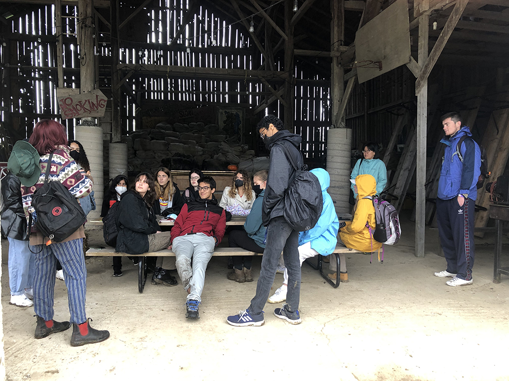 Trinity One students and graduates visit The New Farm in Creemore: October 2021. Group photo of students sitting inside a barn.