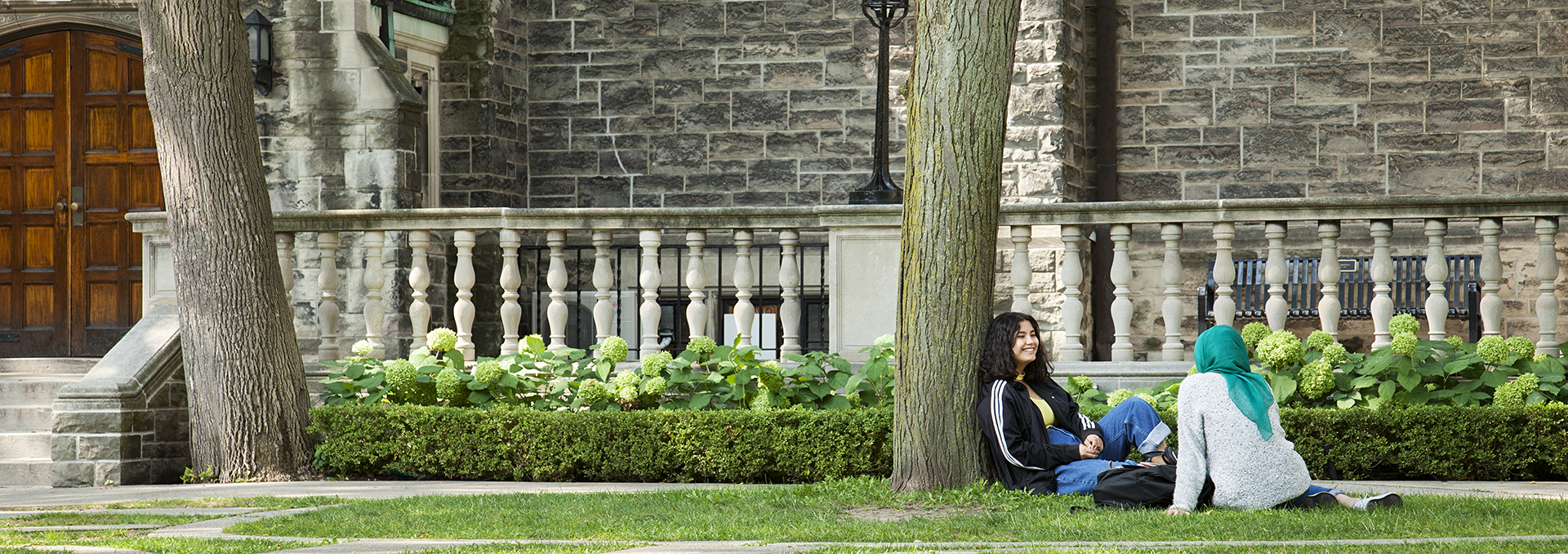 Two students sitting on grass in the Quad