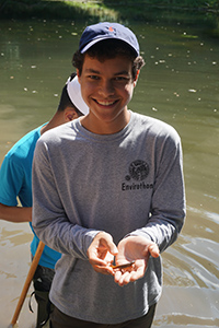 Trinity One Student holds a Salamander at the Koffler Scientific Reserve